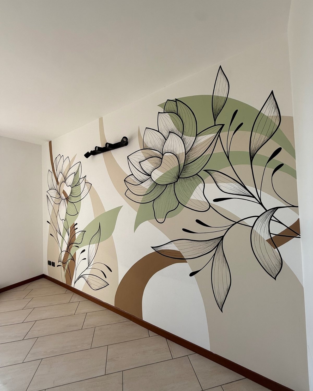 Large floral wall mural with green and tan organic shapes on a white interior wall.