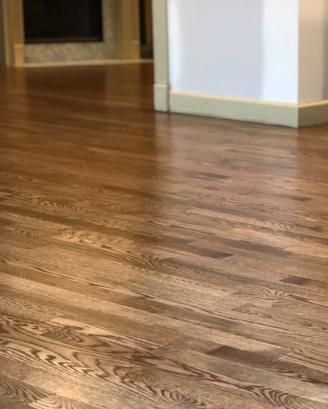 Dark walnut hardwood floor planks with a polished finish in a residential room.