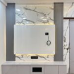 Modern TV unit with marble wall paneling, grey vertical slats, and a white floating console.