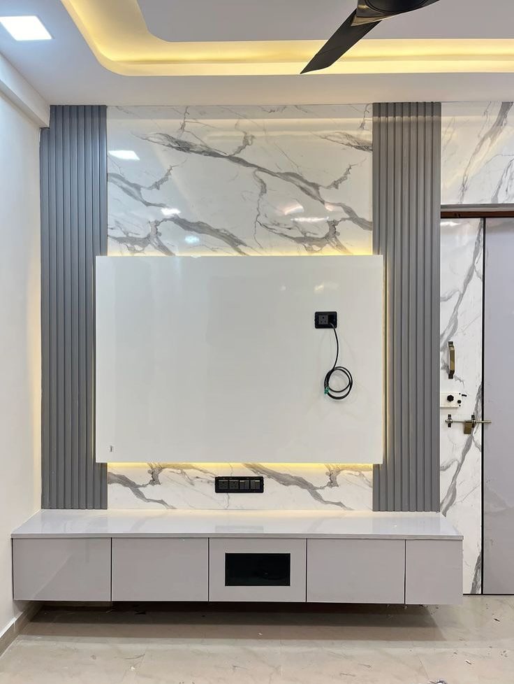 Modern TV unit with marble wall paneling, grey vertical slats, and a white floating console.